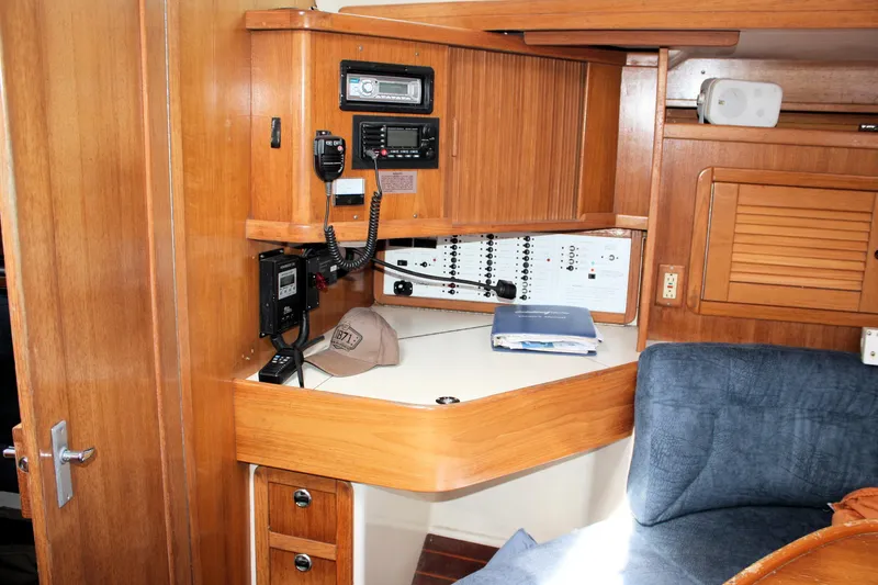 Slide: The Image of Navigation station in 1998 Catalina 42 MkII sailboat with wood cabinetry and communication equipment. - 43
