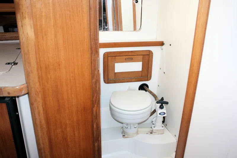 Slide: The Image of 1998 Catalina 42 MkII yacht bathroom with wooden accents and compact marine toilet. - 46