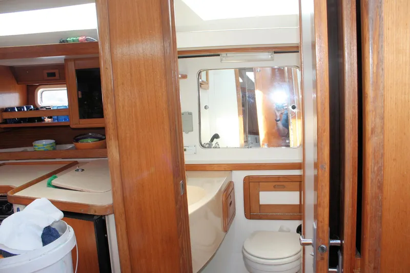 Slide: The Image of Interior of 1998 Catalina 42 MkII sailboat, featuring wooden cabinetry and compact bathroom. - 47