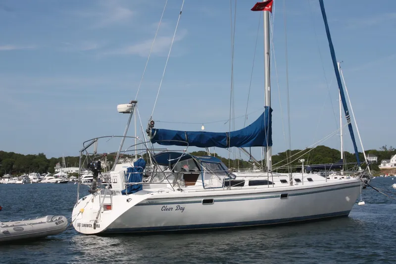 Slide: The Image of 1998 Catalina 42 MkII sailboat anchored in a scenic harbor with blue skies. - 8