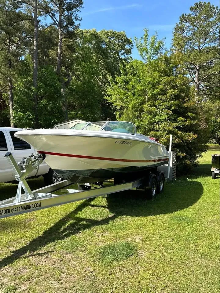 The Image of 2001 Chris-Craft Launch 22 boat on trailer, surrounded by trees and grass. - 0