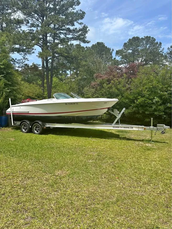 Slide: The Image of 2001 Chris-Craft Launch 22 boat on trailer in grassy area with trees. - 9