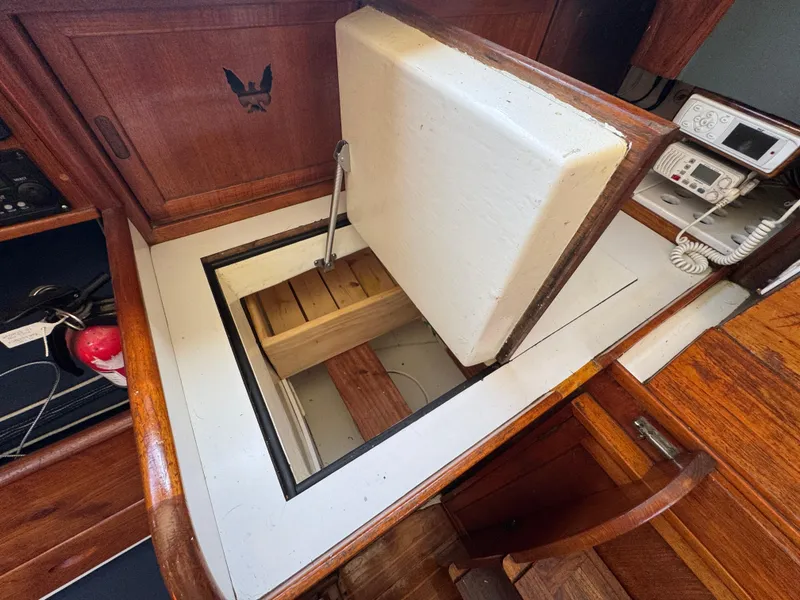Slide: The Image of 1970 Cheoy Lee Luders 36 yacht interior with open storage compartment and navigation equipment. - 18