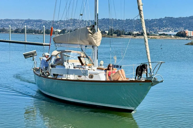 Slide: The Image of 1970 Cheoy Lee Luders 36 sailboat cruising with passengers and a dog on a sunny day. - 2