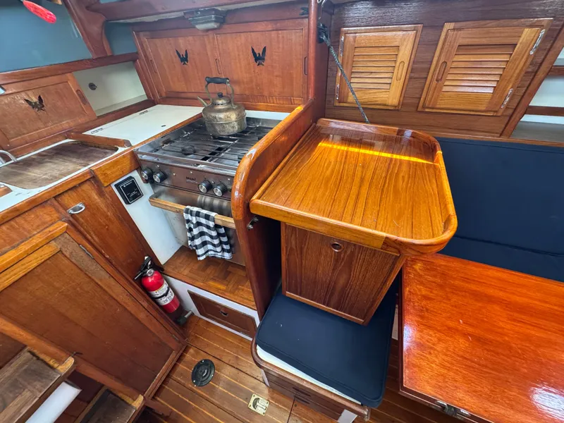 Slide: The Image of 1970 Cheoy Lee Luders 36 yacht interior with wooden cabinetry and stove. - 24