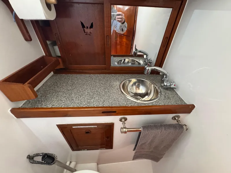 Slide: The Image of 1970 Cheoy Lee Luders 36 yacht bathroom with sink, mirror, and wooden cabinetry. - 27