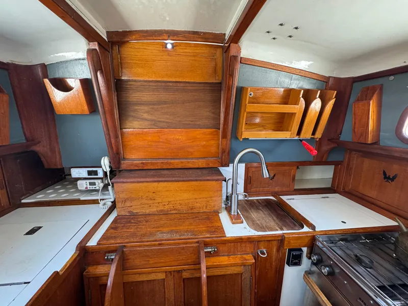 Slide: The Image of Interior of 1970 Cheoy Lee Luders 36 sailboat with wooden cabinetry and compact kitchen area. - 31