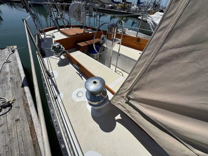Slide: The Image of 1970 Cheoy Lee Luders 36 sailboat deck with winches and wooden accents at marina. - 36