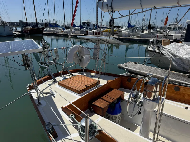 Slide: The Image of 1970 Cheoy Lee Luders 36 sailboat docked in marina, featuring solar panel and wooden deck. - 38