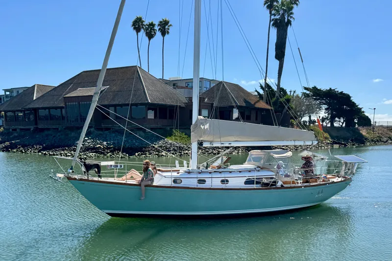 Slide: The Image of 1970 Cheoy Lee Luders 36 sailboat on calm water, with people relaxing onboard. - 5