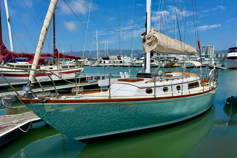 Slide: The Image of 1970 Cheoy Lee Luders 36 sailboat docked in a marina under a clear blue sky. - 6