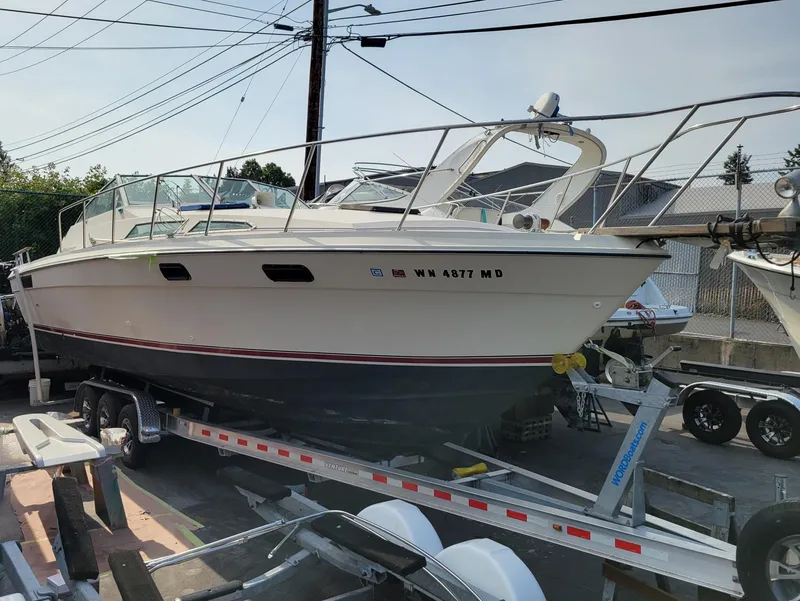 The Image of 1979 Bayliner 3250 boat docked on calm water, industrial background. - 0