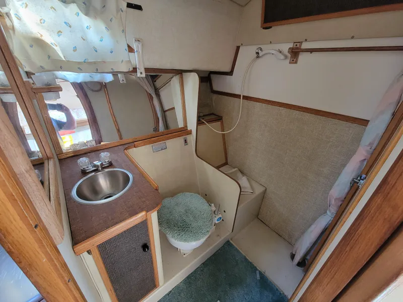 Slide: The Image of 1979 Bayliner 3250 boat deck with shadow, surrounded by other boats in a marina. - 12