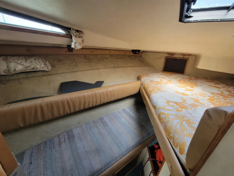 Slide: The Image of Interior of a 1979 Bayliner 3250 boat with cozy seating and wooden table. - 13