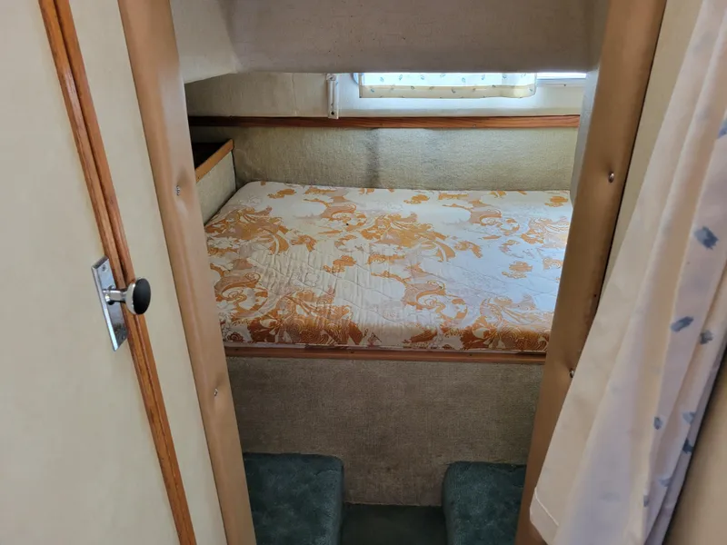 Slide: The Image of 1979 Bayliner 3250 cabin interior with floral bedspread and window. - 19