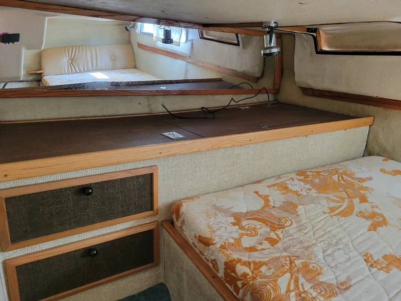 Slide: The Image of 1979 Bayliner 3250 cabin interior with bed, storage drawers, and wood accents. - 20