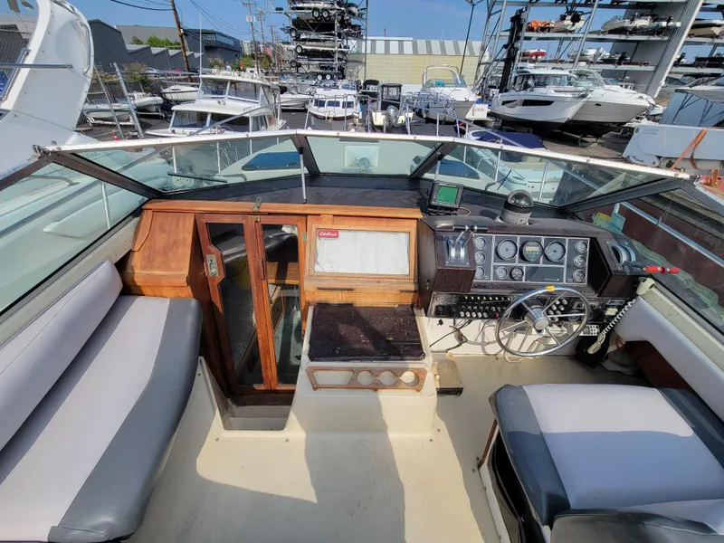 Slide: The Image of 1979 Bayliner 3250 boat docked at marina, featuring a covered cockpit and sleek design. - 3