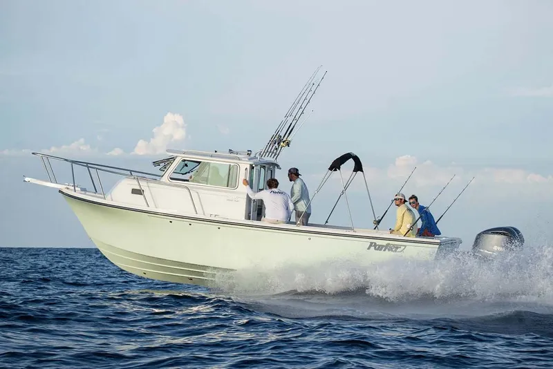 Slide: The Image of 2025 Parker 2820 XLD Sport Cabin boat cruising on open water with passengers. - 2