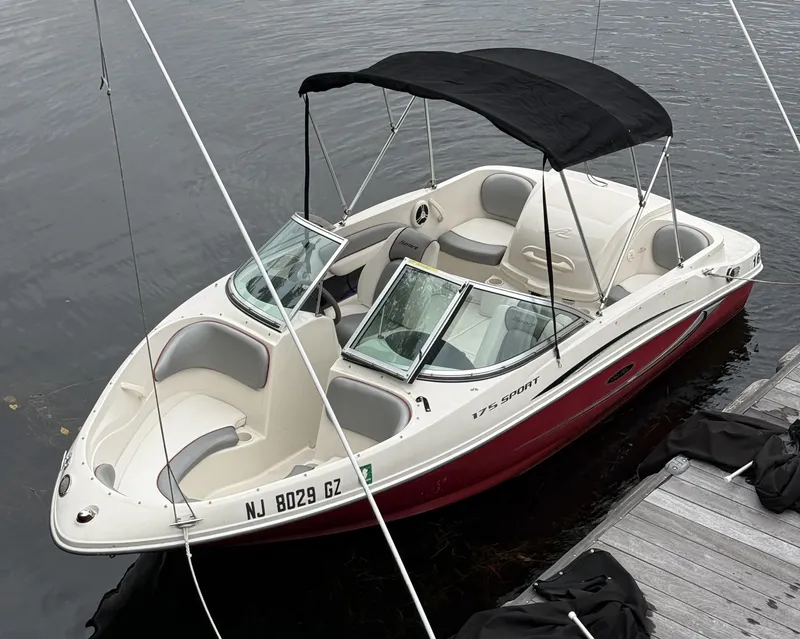The Image of 2008 Sea Ray 175 Sport boat docked, featuring a sleek design and black canopy. - 0
