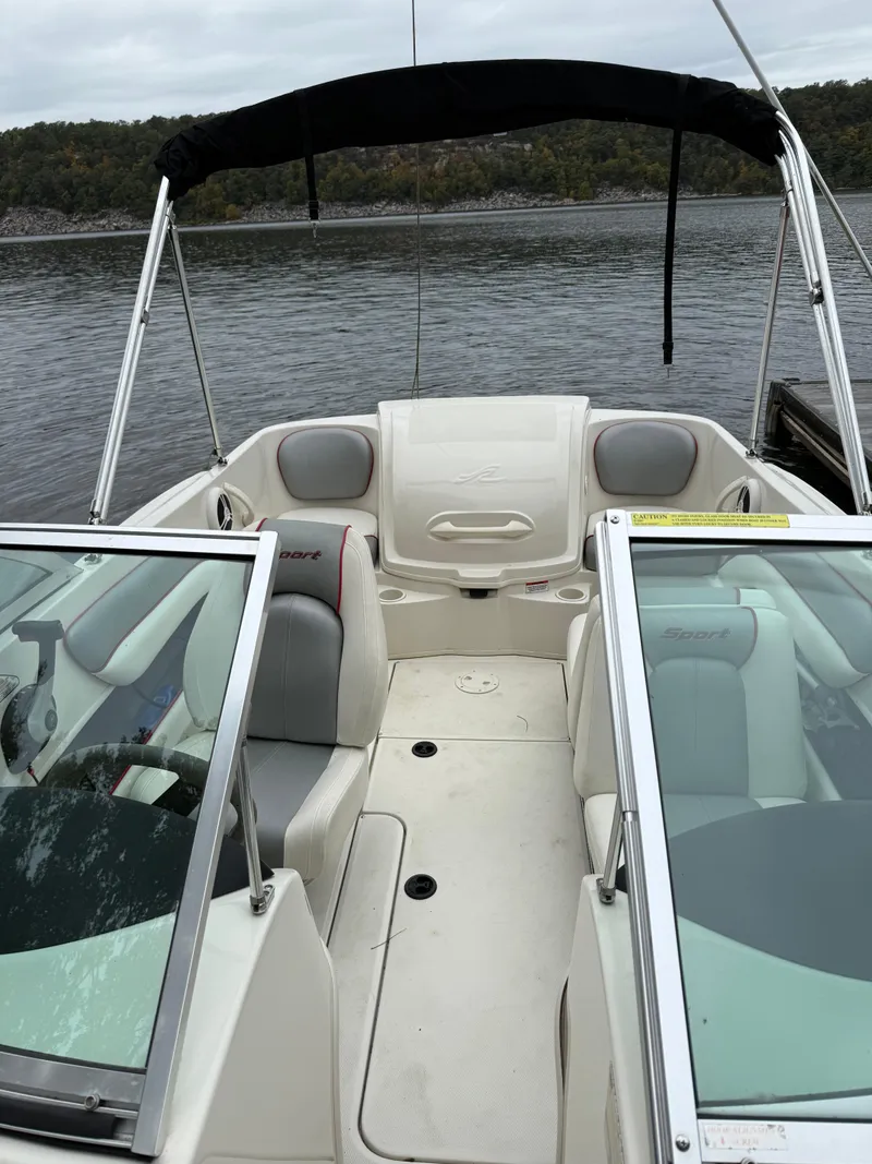 Slide: The Image of 2008 Sea Ray 175 Sport boat interior with seating and canopy on a calm lake. - 8