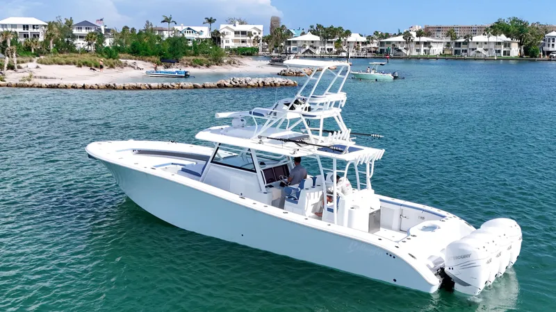 The Image of 2023 Yellowfin 42 boat cruising in clear blue waters near a coastal town. - 0