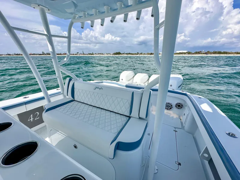 Slide: The Image of 2023 Yellowfin 42 boat interior with seating, ocean view, and clear skies. - 11