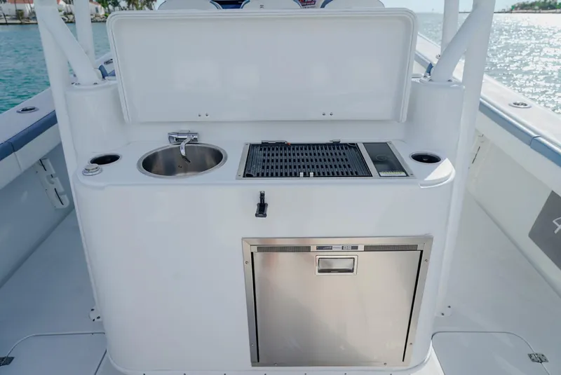 Slide: The Image of 2023 Yellowfin 42 boat kitchenette with sink, grill, and storage on deck. - 14