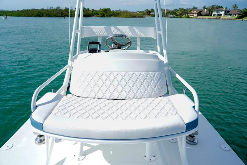 Slide: The Image of 2023 Yellowfin 42 boat with white cushioned seating on calm water. - 18