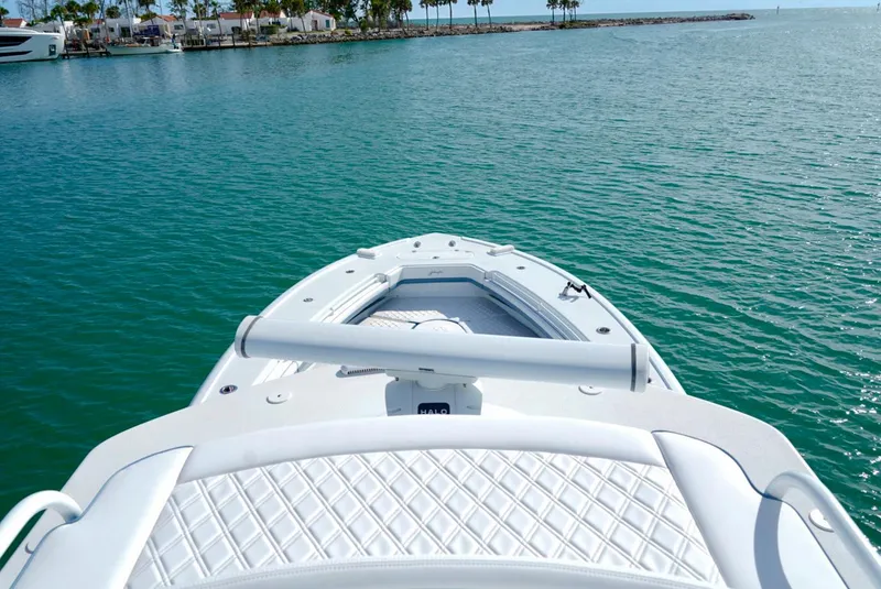 Slide: The Image of 2023 Yellowfin 42 boat on calm turquoise water near a marina. - 20