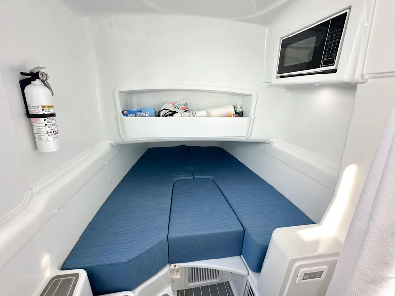 Slide: The Image of 2023 Yellowfin 42 interior cabin with blue cushions, microwave, and fire extinguisher. - 29