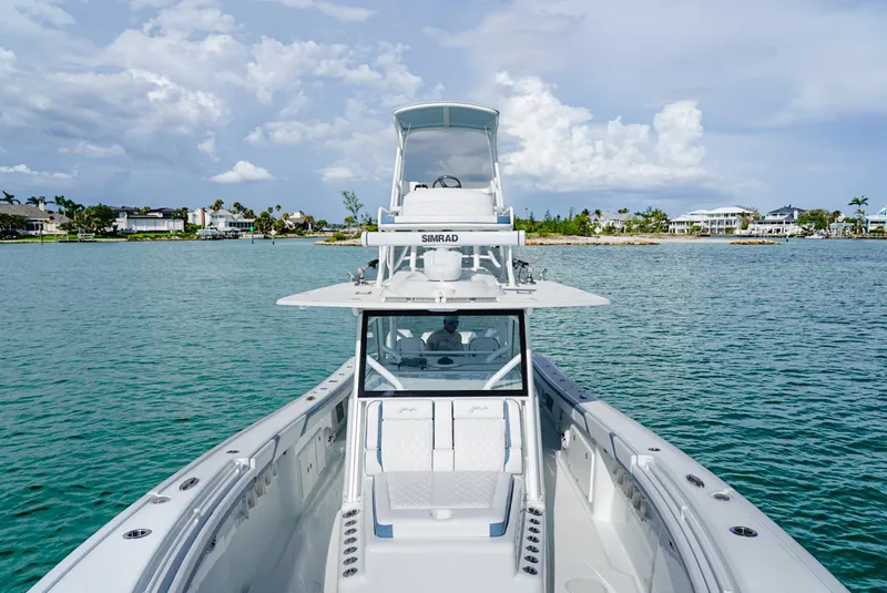 Slide: The Image of 2023 Yellowfin 42 boat on calm water with coastal background. - 4