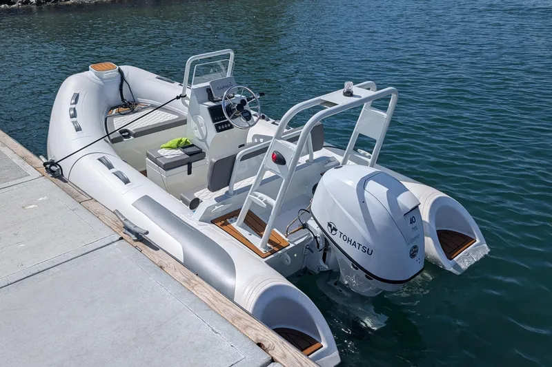 Slide: The Image of Tide Craft Nantucket 12 boat, 2025 model, docked with Tohatsu engine, in calm waters. - 3