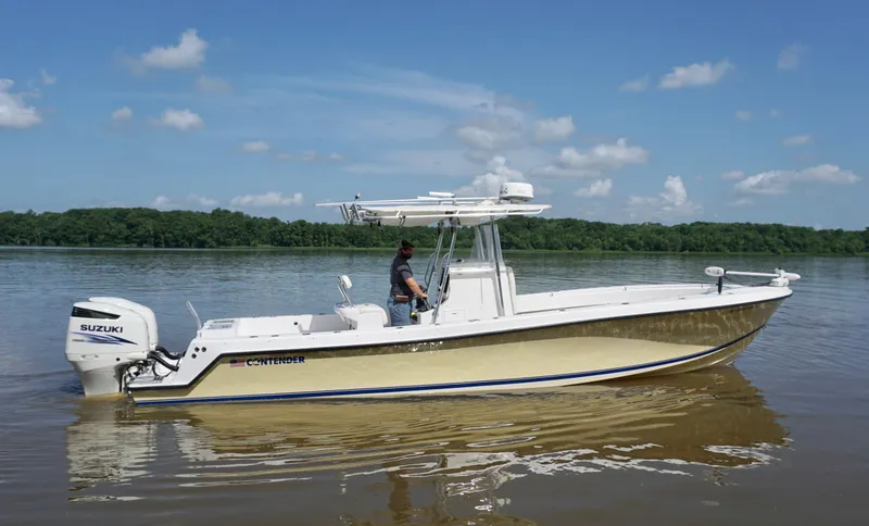 Slide: The Image of 2003 Contender 31 Open boat on calm water with Suzuki engine, clear sky background. - 0