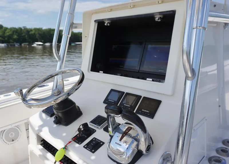 Slide: The Image of 2003 Contender 31 Open boat dashboard with steering wheel and navigation controls. - 15