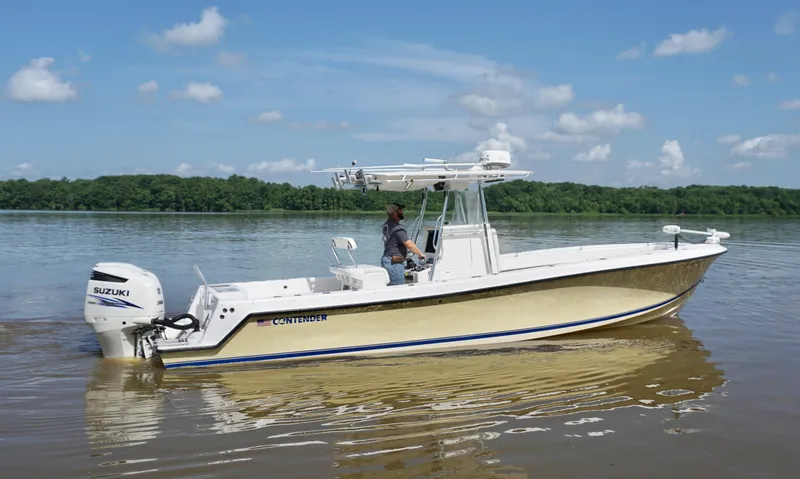 Slide: The Image of 2003 Contender 31 Open boat on calm water, featuring Suzuki outboard engine. - 2
