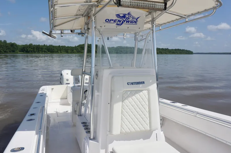 Slide: The Image of 2003 Contender 31 Open boat on calm water, featuring a spacious deck and dual engines. - 20