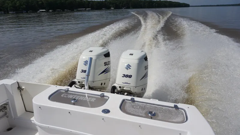 Slide: The Image of 2003 Contender 31 Open boat with dual Suzuki 300 engines cruising on a lake. - 24