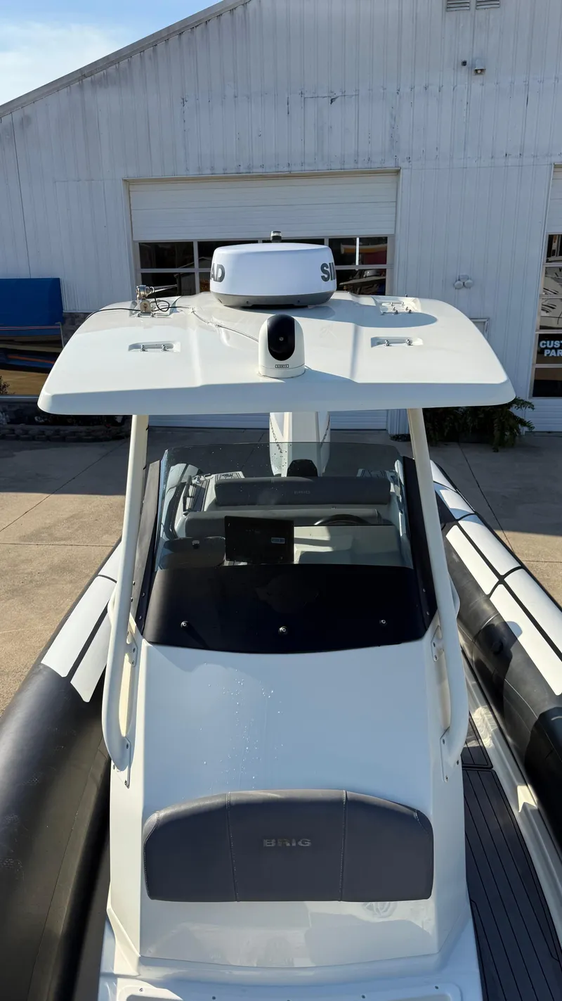 Slide: The Image of 2022 Brig Eagle 8 boat with sleek design, docked near a white building. - 14