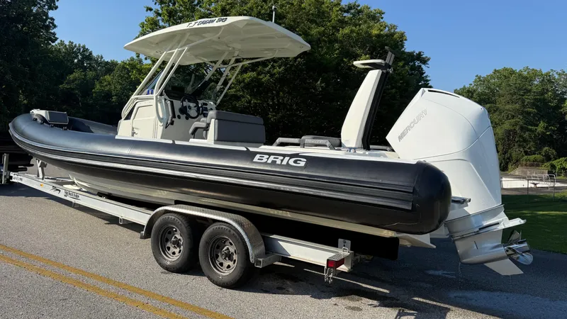 Slide: The Image of 2022 Brig Eagle 8 boat on trailer, featuring Mercury outboard engine, parked on road. - 3