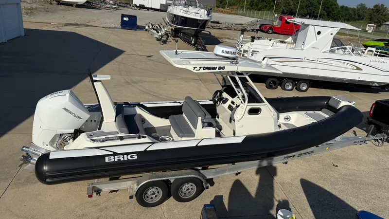 Slide: The Image of 2022 Brig Eagle 8 boat on trailer, featuring Mercury engine, parked outdoors. - 6