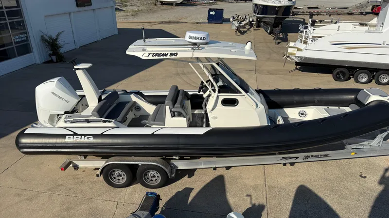 Slide: The Image of 2022 Brig Eagle 8 boat on trailer, featuring Mercury engine, parked at marina. - 7