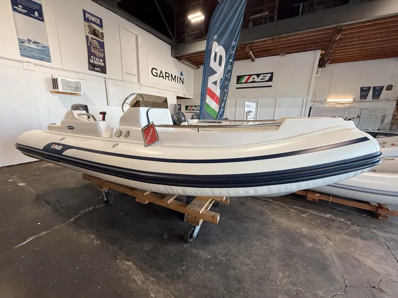 Slide: The Image of 2024 AB Inflatables Nautilus 15 DLX boat displayed indoors on a wooden stand. - 13