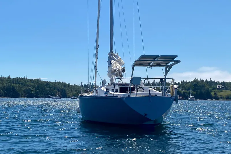 The Image of 1982 Tartan 37 sailboat anchored on a sunny day with scenic shoreline. - 0