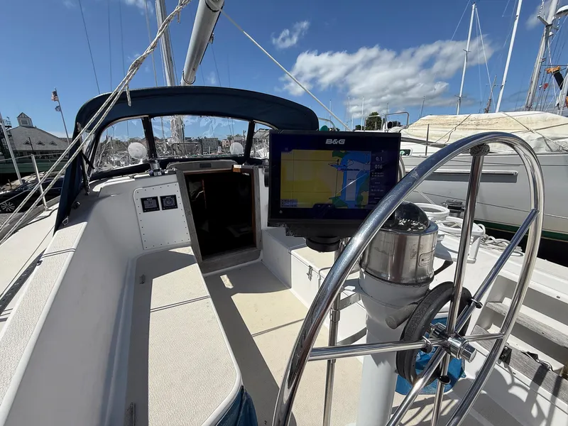 Slide: The Image of 1982 Tartan 37 sailboat cockpit with navigation system and steering wheel under blue sky. - 11