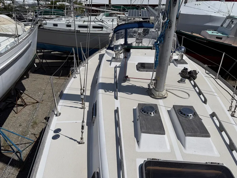 Slide: The Image of 1982 Tartan 37 sailboat on dry dock, surrounded by other boats. - 19