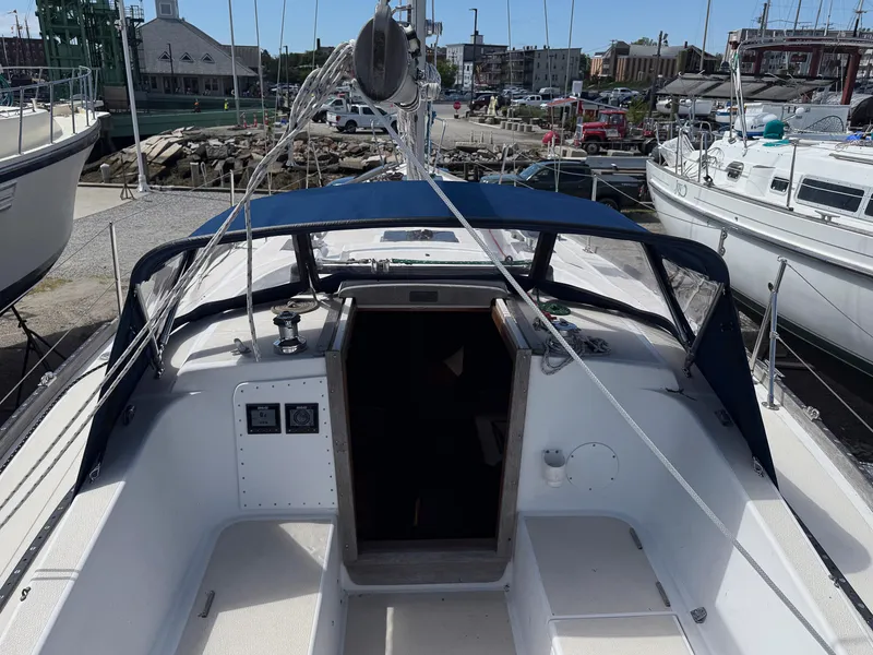 Slide: The Image of 1982 Tartan 37 sailboat cockpit with blue canopy, docked at marina. - 22