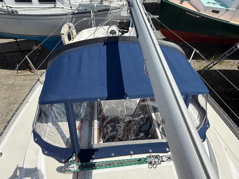 Slide: The Image of 1982 Tartan 37 sailboat with blue canopy, docked alongside other boats. - 23