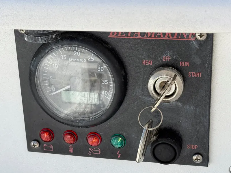 Slide: The Image of Control panel of a 1982 Tartan 37 sailboat with RPM gauge and ignition key. - 24