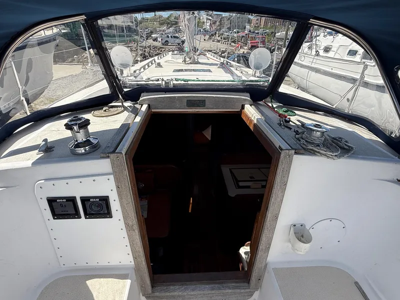 Slide: The Image of Cockpit view of a 1982 Tartan 37 sailboat, showcasing navigation instruments and entryway. - 26