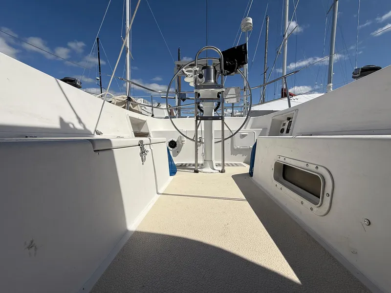Slide: The Image of 1982 Tartan 37 sailboat cockpit with steering wheel, under clear blue sky. - 29